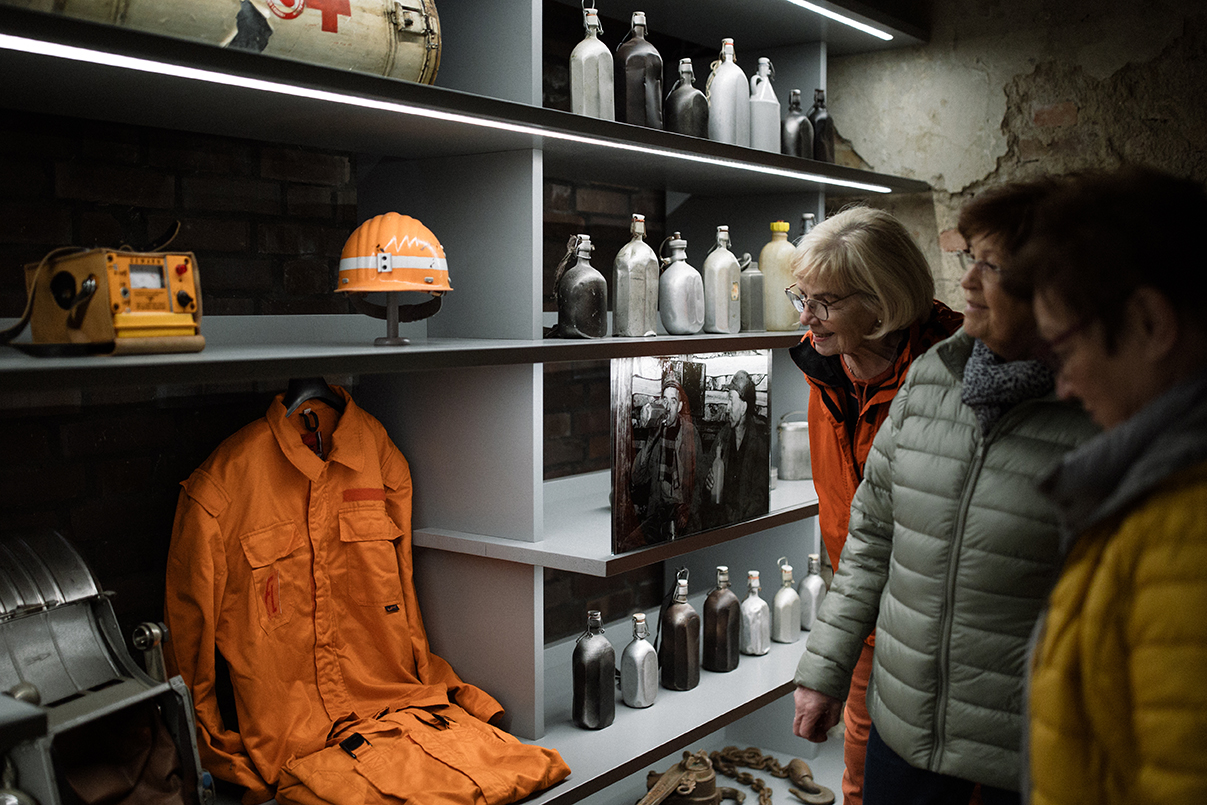 Besucherinnen vor einer Vitrine mit Bergmannsutensilien
