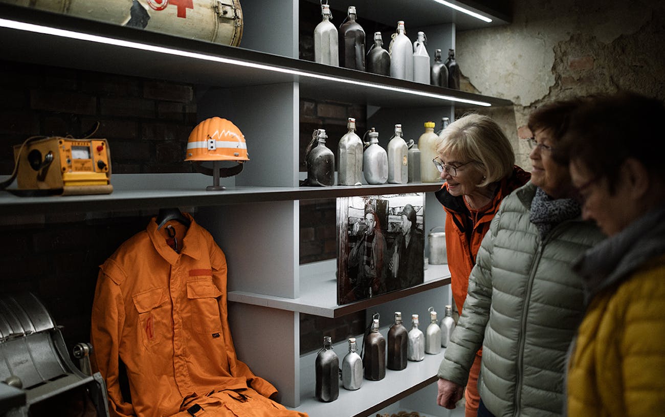 Besucherinnen vor einer Vitrine mit Bergmannsutensilien